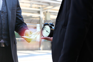 two business men with money and time . business man using money buying time that he can manage time 