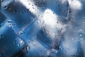 Ice cubes in a misted glass with drops of ice water close-up macro. Soft Selective Focus