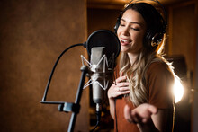 Woman Singing And Recording Songs In Music Studio