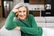 © Vadim Pastuh - Portrait of charming senior woman with grey hair, smiling mature female sits on the couch at ease and looks at the camera. Beautiful carefree middle-aged woman at home