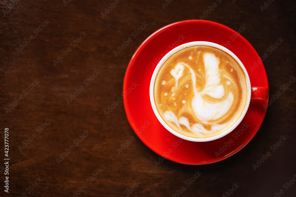 Cup of coffee with latte art on wooden background