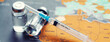 © Thaut Images - Medical syringe with a needle and a bollte with vaccine on world map.