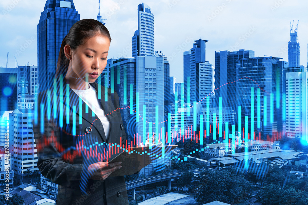 Attractive Asian trader in suit examine her notes to predict the market ...