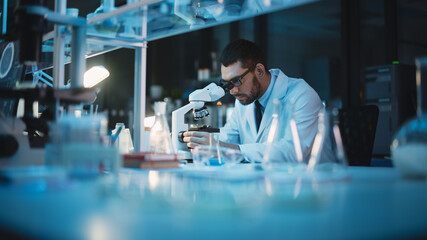 medical development laboratory: caucasian female scientist looking under microscope, analyzes petri 