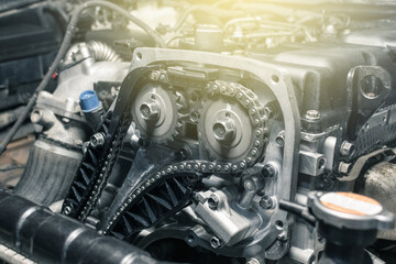 Wall Mural - New car timing chain on a diesel old engine in a car workshop. Close up. Blur effect.