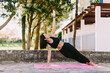 © shevtsovy - beautiful sporty woman yoga asana practice morning routine. Beautiful female fitness model yoga training in the morning. Young girl stretching pose outdoor recreation