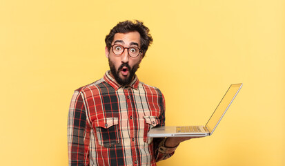 Poster - young crazy bearded man doubting or uncertain expression and a laptop