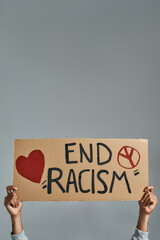 Wall Mural - Placard with End Racism inscription held by man hands