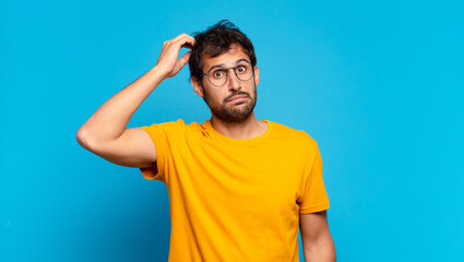 Wall Mural - young handsome indian man doubting or uncertain expression