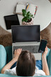 © perfectlab - Young woman using laptop to work home, remote work, multiple devices