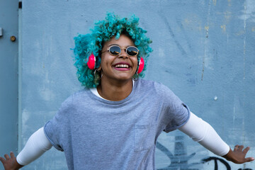 black afro american woman with headphones on the street smiling happy