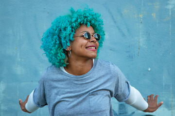 Canvas Print - black afro american woman smiling with sunglasses outdoors on background wall