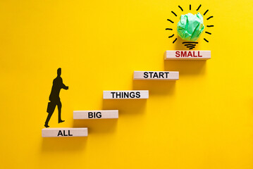 Wall Mural - Business concept growth success process. Wood blocks stacking as step stair on yellow background, copy space. Businessman icon. Words 'all big things start small'. Conceptual image of motivation.
