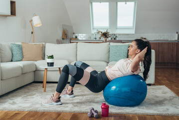 Wall Mural - Woman doing crunches at home