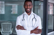 © Wavebreak Media - Portrait of happy african american male doctor wearing stethoscope smiling with arms crossed
