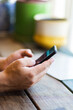 © Clare Seibel-Barnes/Austockphoto - Man sitting at a table using his phone while waiting for food