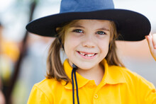 Portrait Of A Happy Young School Girl Outside Wearing A Hat For Sun Protection