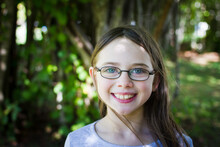 Young Girl Wearing Glasses In Dappled Light