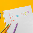 © Tetra Images/TGI/Tetra Images - Emc2 formula on paper and colorful crayons