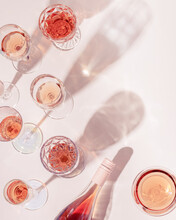 Many Glasses Of Rose Wine And Bottle Sparkling Pink Wine Top View. Light Alcohol Drink For Party.