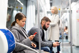 Fototapeta  - People browsing in smartphone in subway. High quality photo