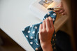 © Svitlana - Female child hands cutting thread in sewing workshop