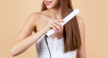 Happy Woman Straightening Hair With Straightener. Beautiful Girl Using Styler On Her Shining Hair. Hairstyle. Beautiful Smiling Woman Ironing Long Hair With Flat Iron