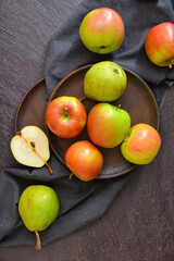 Wall Mural - Plates with tasty apple and pear fruits on dark background