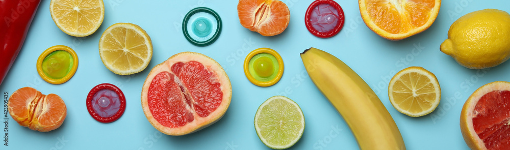 Sex concept with fruits and condoms on blue background - obrazy, fototapety, plakaty 