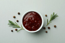 Bowl Of Barbecue Sauce And Spices On Light Gray Background
