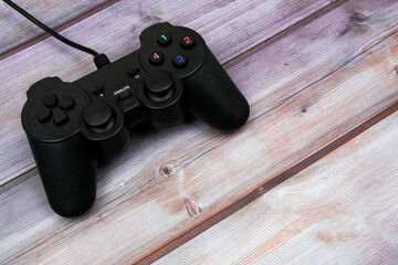 Video game controller isolated on wooden board background with copyspace. Computer player concept. Top view