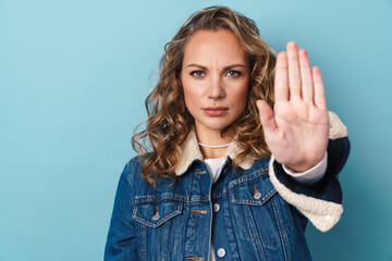 Blonde displeased woman showing stop gesture and looking at camera