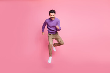 Wall Mural - Photo of charming funky young guy wear violet sweater jumping high running fast isolated pink color background