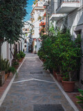 Fototapeta Uliczki - Typical narrow street with flowerpot of Marbella, Costa del Sol, Malaga Province. Empty Andalusian street