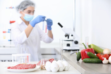 Wall Mural - different food on table and scientist proceeding quality control in laboratory