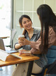 © bongkarn - Kindly female office worker giving coffee to her colleague while working together