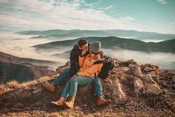 happy couple man and woman tourist at top of mountain during a hike in summer