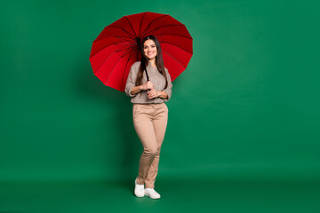 Poster - Photo of young pretty lady hold red parasol wait wear plaid shirt trousers shoes isolated green color background