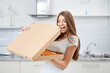 © serhiibobyk - Happy woman opening box pizza with pleasure.