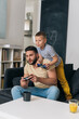 © cherryandbees - father and son playing video games at home
