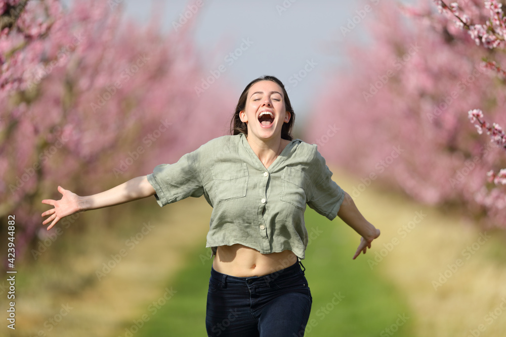 Happy woman running celebrating vacation in a field - obrazy, fototapety, plakaty 