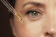 Female eye and dropper with rejuvenating serum