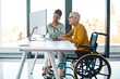 © NDABCREATIVITY - Senior business woman in wheelchair working in office