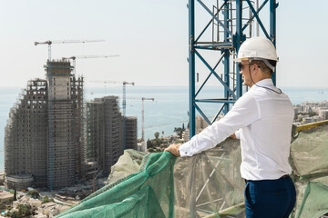 Confident architect or businessman wearing hard hat looking on a construction site