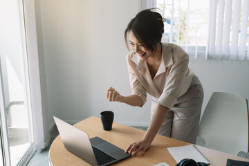 Excited Asian Businesswoman Celebrating Success At Workplace.