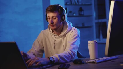 Male worker using different devices on a colorful neon light background
