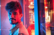 © alvaro - young hispanic man close to a neon light with blue and red lights