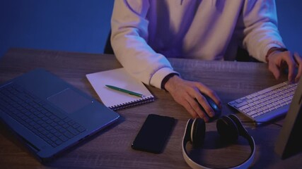 Male hands using different devices with a colorful neon light background