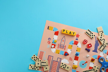 Wall Mural - Components of board games on light blue background, flat lay. Space for text