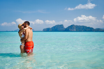 Wall Mural - Romantic couple kissing on paradise tropical beach with copy space